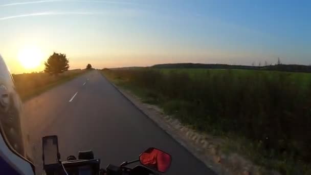 Um motociclista ao volante de uma motocicleta durante uma viagem de carro ao pôr do sol — Vídeo de Stock