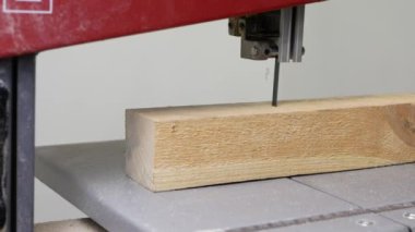 The wooden workpiece is sawn on a band saw.