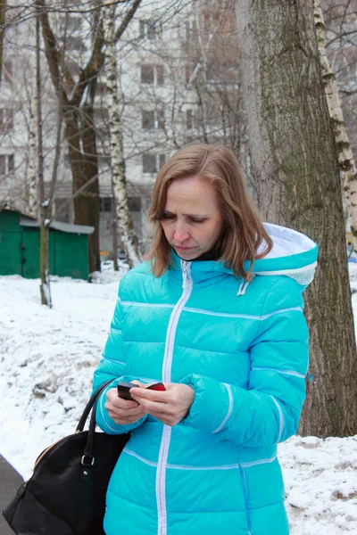 Une femme regarde un téléphone portable — Photo