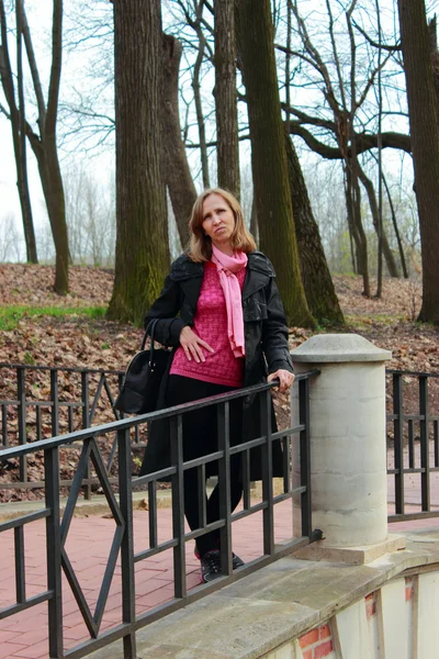 Kobieta w czarny płaszcz stojąc na moście — Zdjęcie stockowe