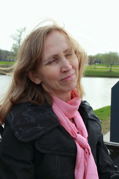 Woman resting near a pond — Stock Photo, Image