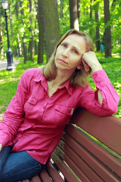 Mujer descansando sentada en el banco del parque — Foto de Stock