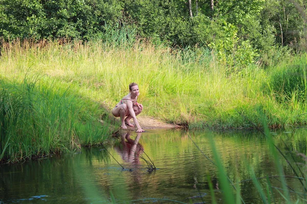 Kvinna i baddräkt nära floden — Stockfoto