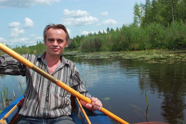 bir adam bir kayık içinde yüzüyor.