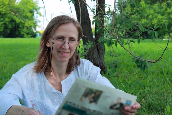 Uma mulher lendo um jornal — Fotografia de Stock