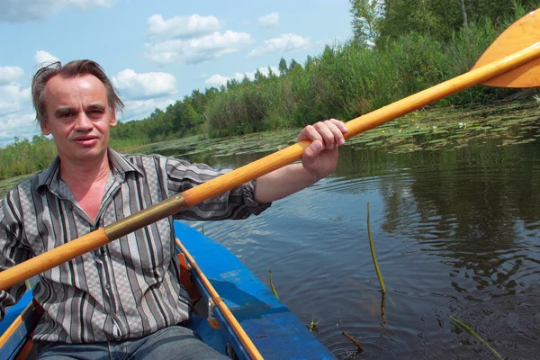 bir adam bir kayık içinde yüzüyor.