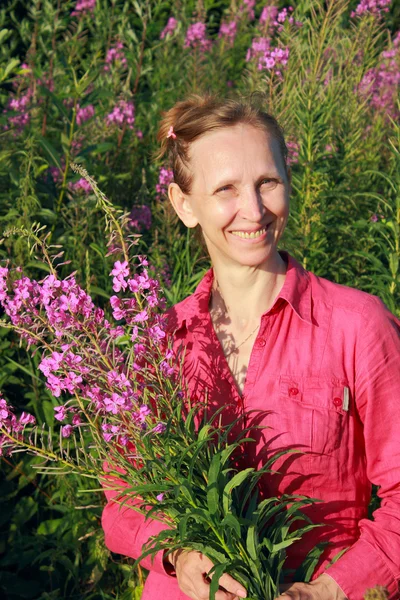 Una mujer recogiendo flores sauce-hierba —  Fotos de Stock