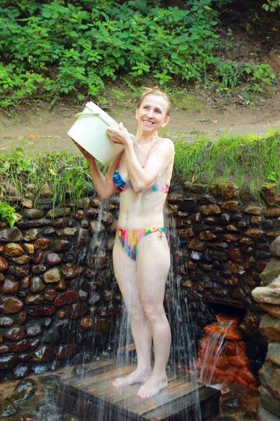 Una mujer vierte manantial de agua — Foto de Stock