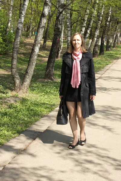Eine Frau in einem schwarzen Mantel — Stockfoto