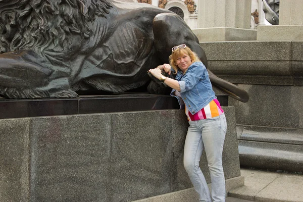 Kobieta stoi w pobliżu rzeźba lwa — Zdjęcie stockowe