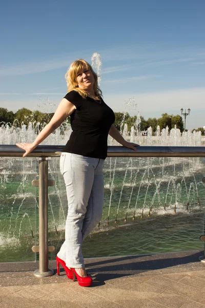 Žena stojí u fontány — Stock fotografie