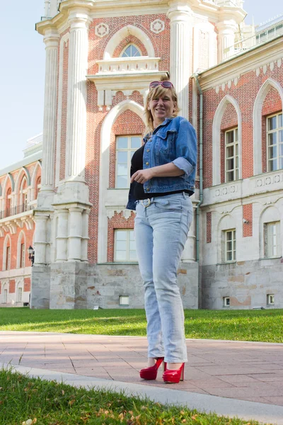 A woman in a blue jacket walking near the Tsaritsyno palace in t — Stock Photo, Image