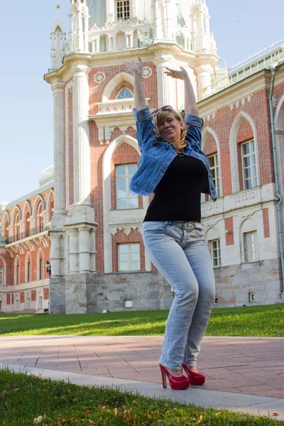 Una mujer con una chaqueta azul caminando cerca del palacio Tsaritsyno en t — Foto de Stock