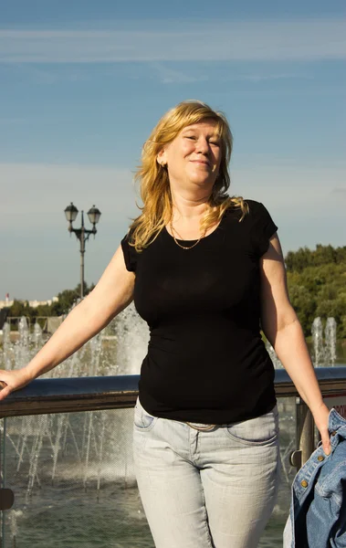 Une femme se tient près d'une fontaine — Photo