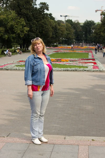 Una mujer con chaqueta azul y jeans azul claro —  Fotos de Stock