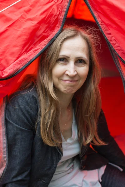 Uma mulher olha para fora de uma tenda — Fotografia de Stock