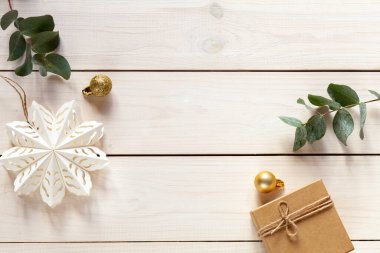 Beyaz ahşap Noel arkaplanı kağıt kar tanesi ve altın Noel topları, üst manzara
