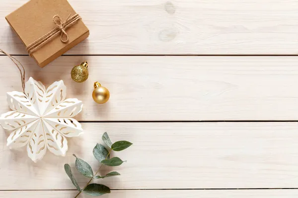 紙の雪の結晶と金のクリスマスボールと白い木のクリスマスの背景 トップビュー — ストック写真