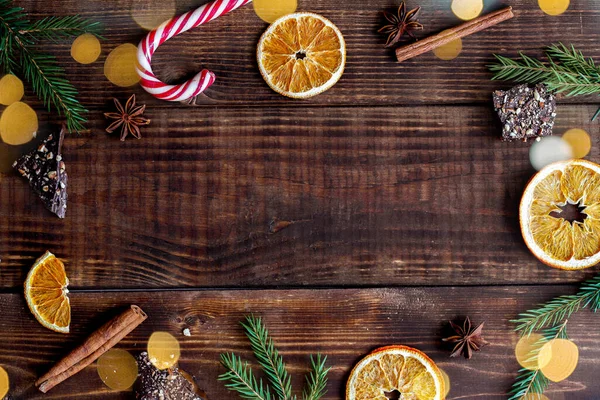 Portakallı, köknar dallı, tarçınlı ve çikolatalı tahta Noel arkaplanı. Kış sıcacık arkaplan, üst görünüm