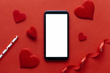Kırmızı arka planda tablet ve kırmızı kalpler, Sevgililer Günü konsepti