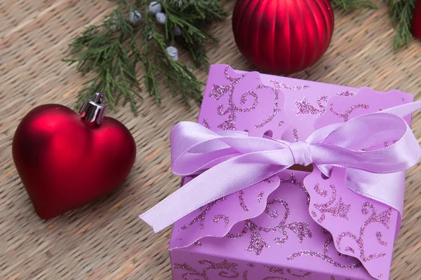 Noel mor hediye kutu kırmızı top ve kalp ile dekore edilmiş — Stok fotoğraf