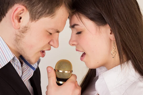 Мужчина и женщина поют за микрофоном — стоковое фото