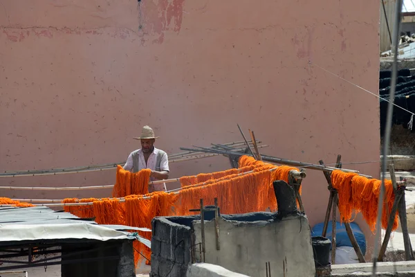 Man dyeing fabric in a market, Marrakesh, Morocco — Stock Photo, Image