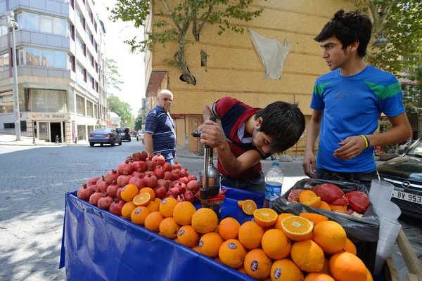 Man trades fresh pomegranate and orange juice — Stock Photo, Image