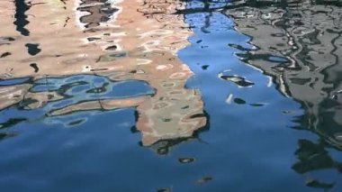 Sakin sular Venedik, İtalya 'daki geleneksel Venedik evlerini yansıtıyor. Dalgalar sudaki yansımaları bozuyor.