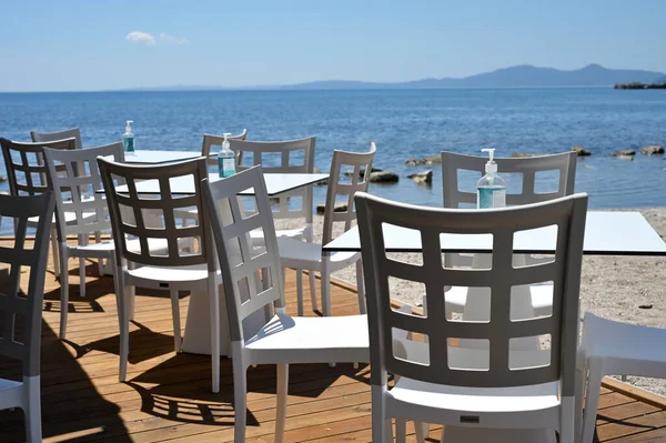 Pusta Restauracja Wybrzeżu Butelki Środkiem Dezynfekującym Stołach Mycia Rąk Grecja — Zdjęcie stockowe