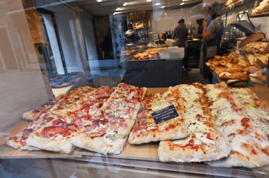 Venedik, İtalya - 3 Kasım 2021: Pizzacı cam pencere. İtalya 'da Venedik' te bir dükkan vitrininde çeşitli İtalyan pizzaları, sokak yemekleri.
