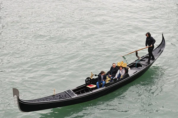 Venedik, İtalya - 03 Kasım 2021: Venedik, İtalya 'da turistlerle dolu bir gondol dar bir kanal boyunca yüzüyor
