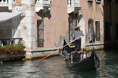 Venedik, İtalya - 4 Kasım 2021: Venedik, İtalya 'da turistlerle dolu bir gondol dar bir kanal boyunca yüzüyor