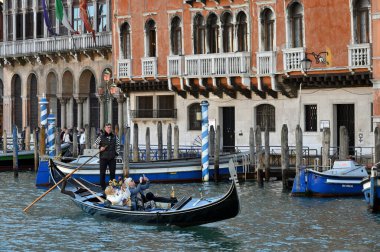 Venedik, İtalya - 4 Kasım 2021: Venedik, İtalya 'da turistlerle dolu bir gondol dar bir kanal boyunca yüzüyor