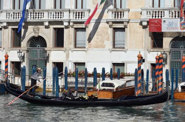 Venedik, İtalya - 4 Kasım 2021: Venedik, İtalya 'da turistlerle dolu bir gondol dar bir kanal boyunca yüzüyor