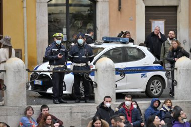 Roma, İtalya - 14 Şubat 2022: Polis Trevi çeşmesi yakınlarında akşam saatlerinde İtalya 'da turist kalabalığının içinde