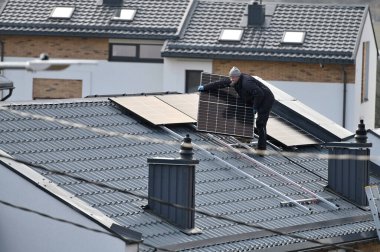 Vilnius, Litvanya - Nisan 06, 2022: Vilnius, Litvanya 'da çatıya güneş panelleri kuran adam.