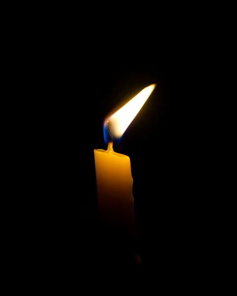 Одиночна помаранчева яскрава свічка з чорним тлом — стокове фото