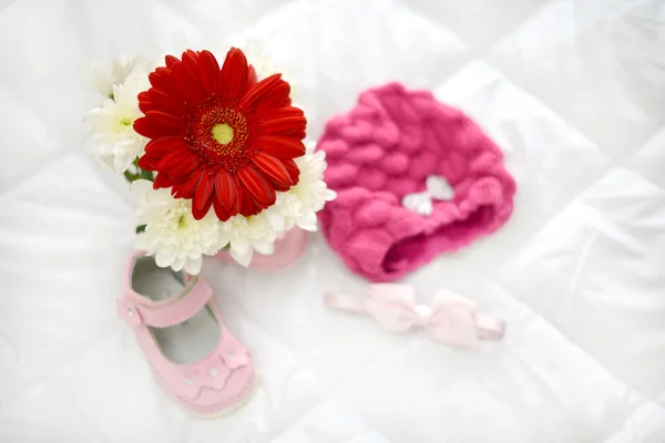 Gerbera pink and baby shoes — Stock Photo, Image