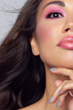 Dudaklarında pembe ruj ve siyah göz kalemi olan seksi bir kadının yüzünün yarısı. Klasik makyaj ve düz uzun saç. Akşam makyajı, kozmetik, kaplıca, kozmetik, gençleştirme.