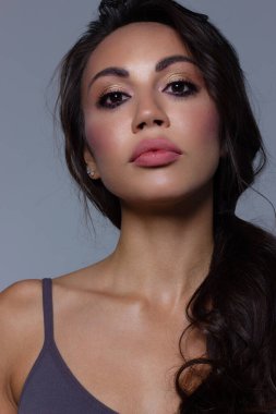 Kahverengi gözlü ve mükemmel makyajlı güzel esmer model kadın yüzü. Pembe dudaklı güzel esmer kız portresi. Açık tenli, yakın planda bir kadın yüzü. Cilt bakımı