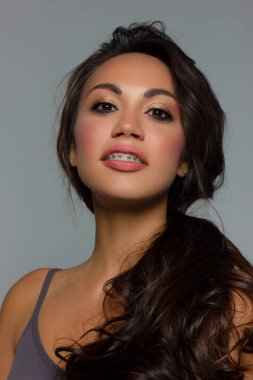 Kahverengi gözlü ve mükemmel makyajlı güzel esmer model kadın yüzü. Pembe dudaklı güzel esmer kız portresi. Açık tenli, yakın planda bir kadın yüzü. Cilt bakımı