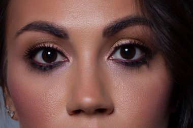Zarif, yakın plan, açık pembe göz farı olan kadın gözü. Güzel bir kadının yüzünün makro görüntüsü. Sağlık, kozmetik ve makyaj. pürüzsüz güzel kaşlar ve kirpiklerle