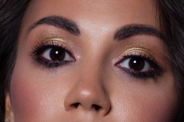 Zarif, yakın plan, açık pembe göz farı olan kadın gözü. Güzel bir kadının yüzünün makro görüntüsü. Sağlık, kozmetik ve makyaj. pürüzsüz güzel kaşlar ve kirpiklerle