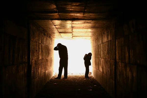 在隧道中的男人和儿童剪影 — 图库照片