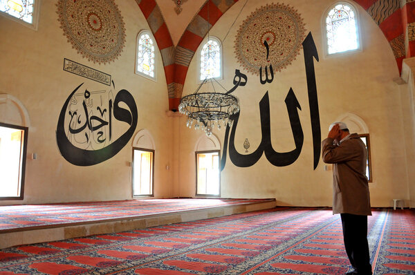 people praying in the mosque and Arabic writings