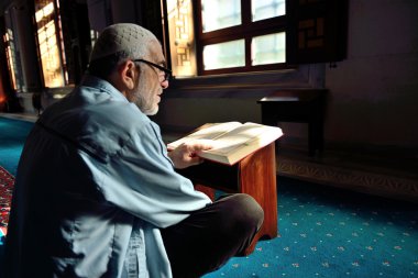 Muslims read the Qur'an in the mosque alone clipart