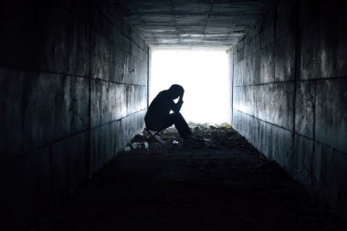 tünelde oturan depresif adam