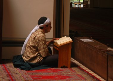 Muslim read the Quran in the mosque alone clipart