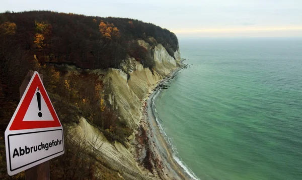 Spiaggia con falesia di gesso e cartello di avvertimento — Foto Stock